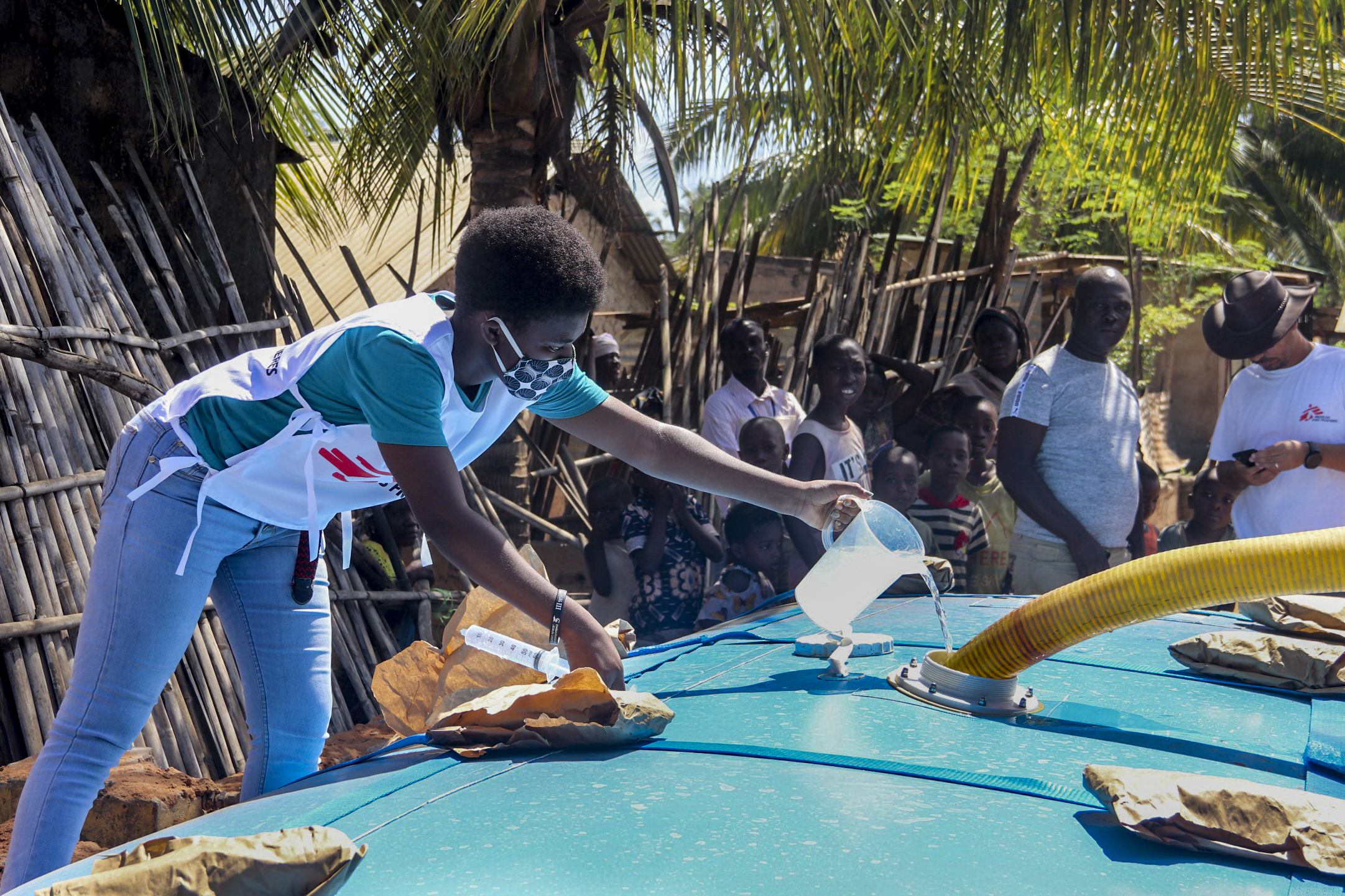 MSF staff member manages water treatment at a distribution site in the Natiti neighborhood of Pemba. April 2020. ©MSF