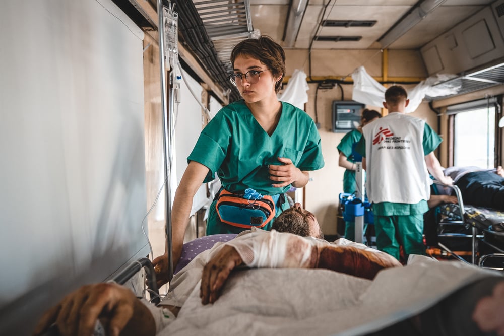 MSF nurse, Anastasia Prudnikova, monitors a war-wounded patient inside the medical train. © Andrii Ovod 