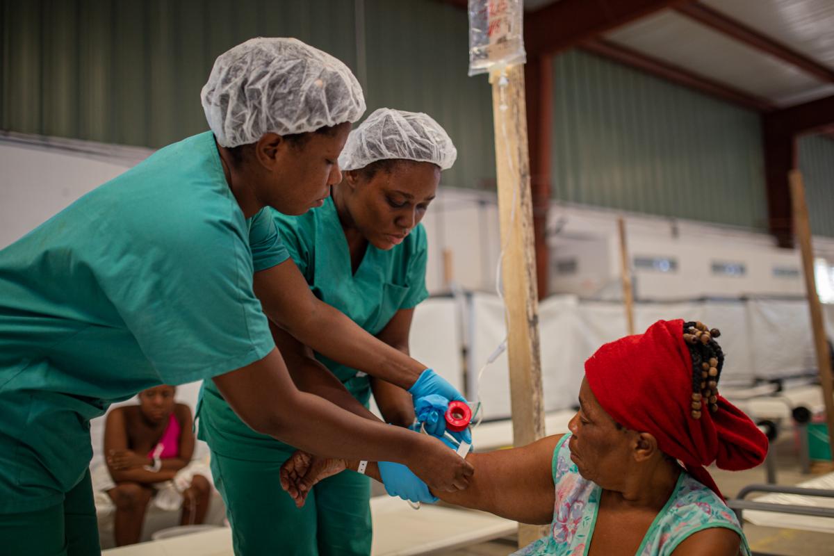 兩名護士為剛抵達位於海地的霍亂治療中心的一名感染霍亂婦女作靜脈注射以補充體液。 © MSF/Alexandre Marcou 