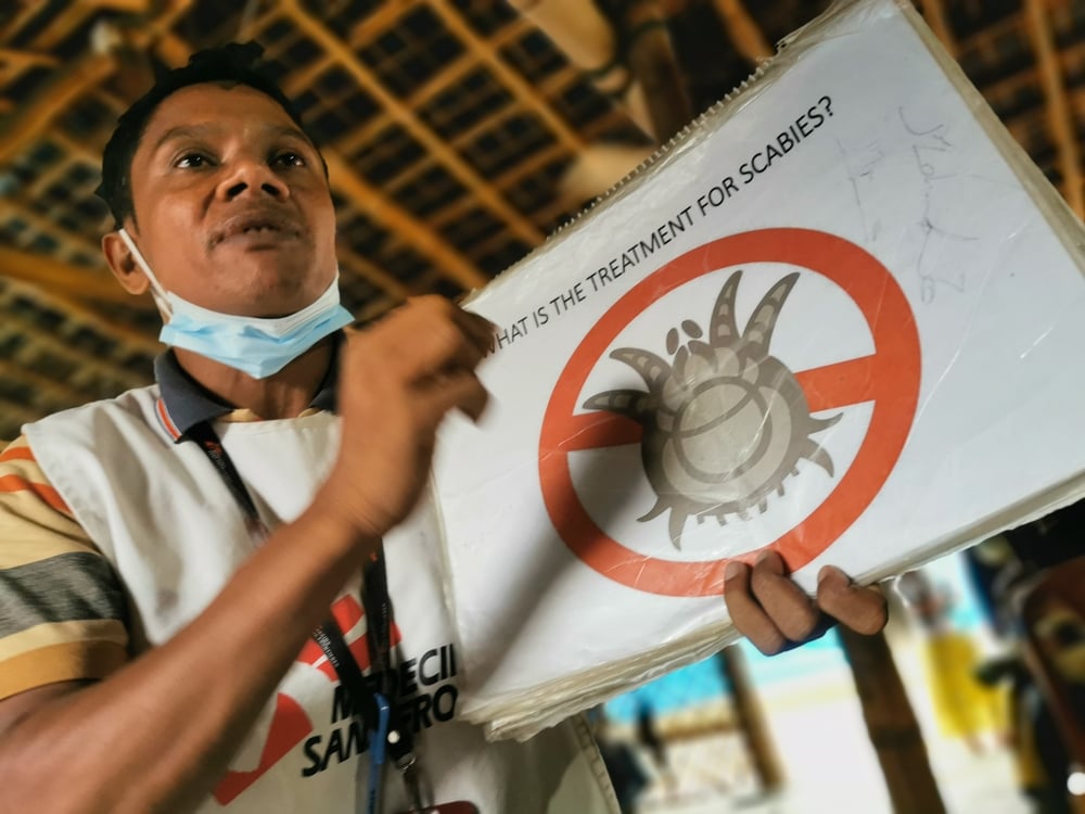 無國界醫生的社區健康推廣義工在診所的候診區，提高人們對疥瘡的認識。© MSF/Malvoisin