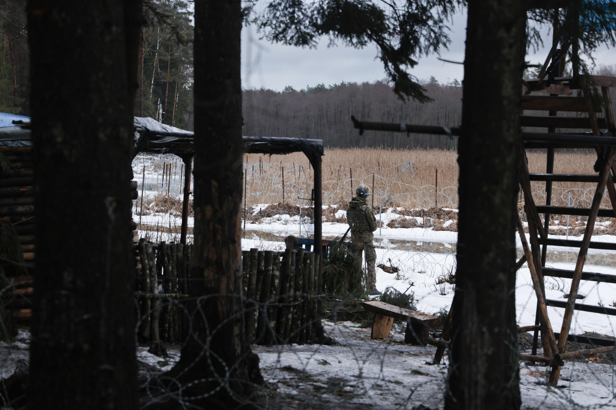 一名波蘭士兵在營地中，他身處瞭望台和一間木屋之間。© Jakub Jasiukiewicz/MSF