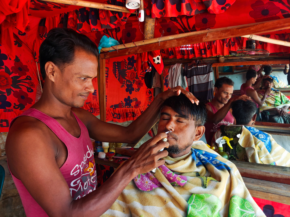 拉赫曼（Rahman）為營內的社區提供理髮服務，而羅興亞難民不能在孟加拉合法工作。© Ro Yassin Abdumonab