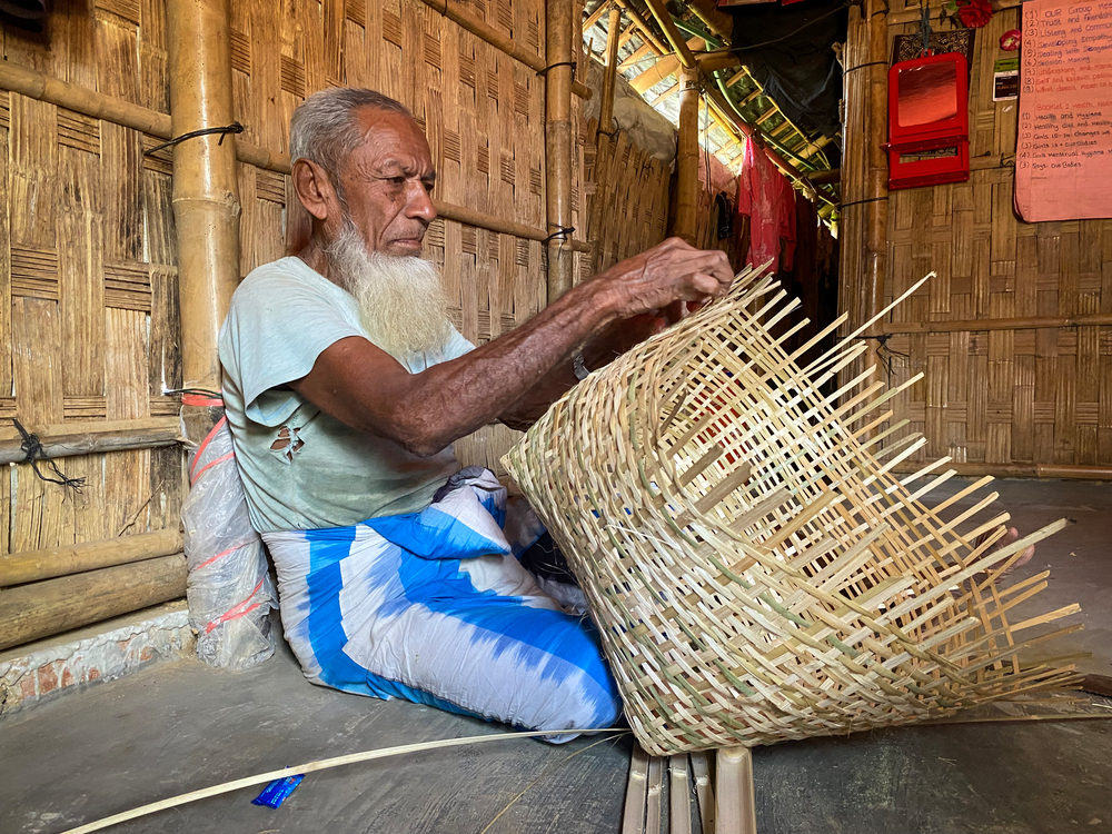 79 歲的穆罕默德（Nur Mohammad）用竹藤製作雞舍。作為一名退伍軍人，他設法賺取足夠的錢以彌補食物援助的不足，並養活一家六口人。© Ishrat Bibi
