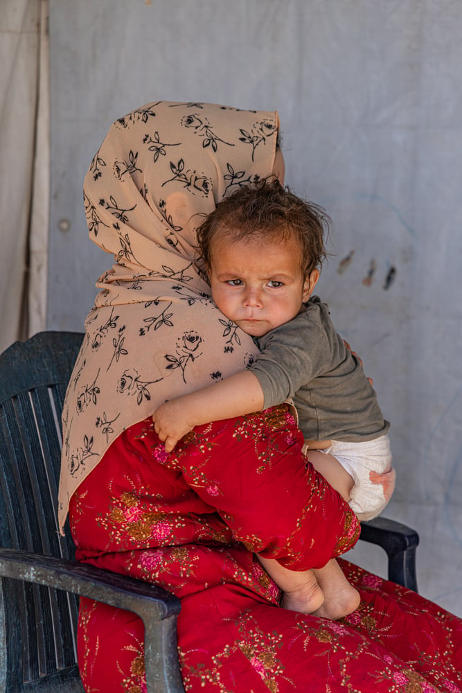 A Syrian mother holds her toddler in northeast Lebanon. "Louai (name changed) has had diarrhea for an entire month, and the trip to the clinic costs much more than I can afford," says his mother. © Carmen Yahchouchi for MSF