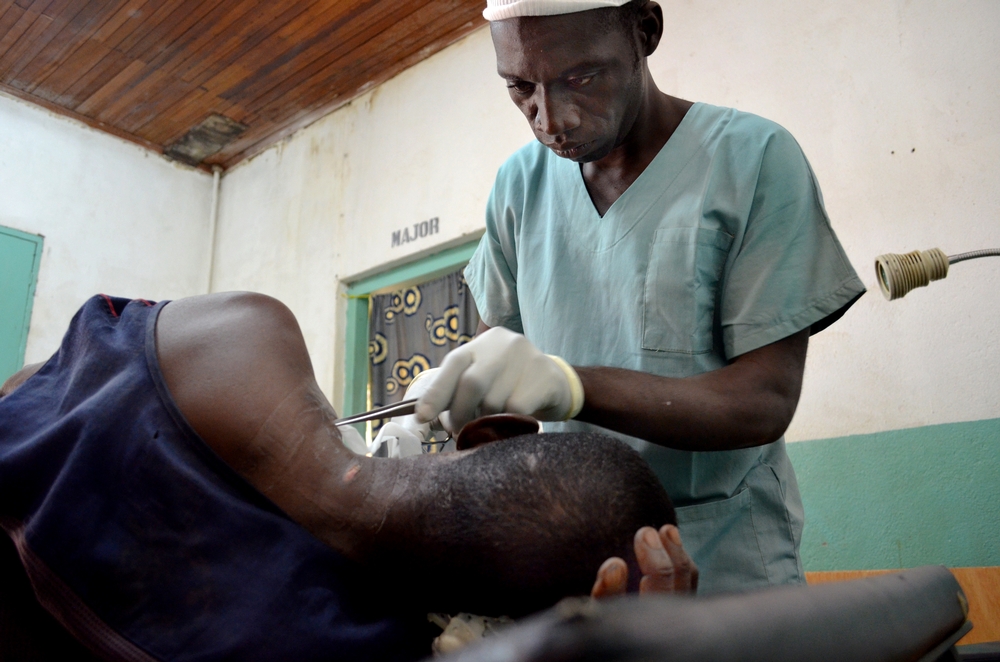 Nurse changes the bandages of a man who was attacked with a hunting rifle in an robbery not far from Kabo where violence is rife. Photo taken on Nov 2016. © Sandra Smiley/MSF