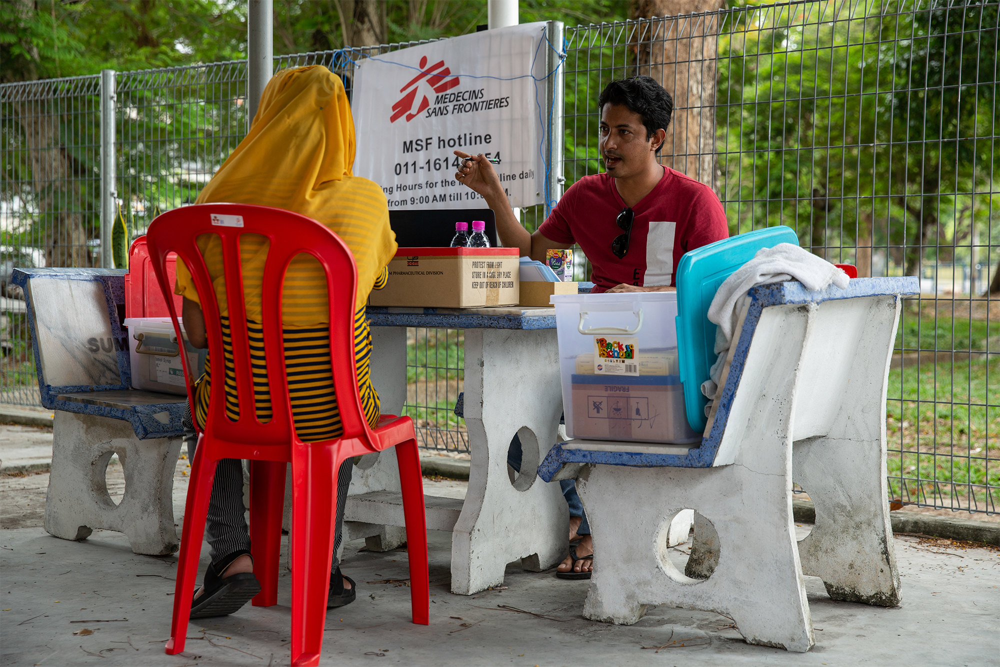 An MSF staff member registers a patient outside the MSF mobile clinic in Bukit Gudung, Penang. © Arnaud Finistre