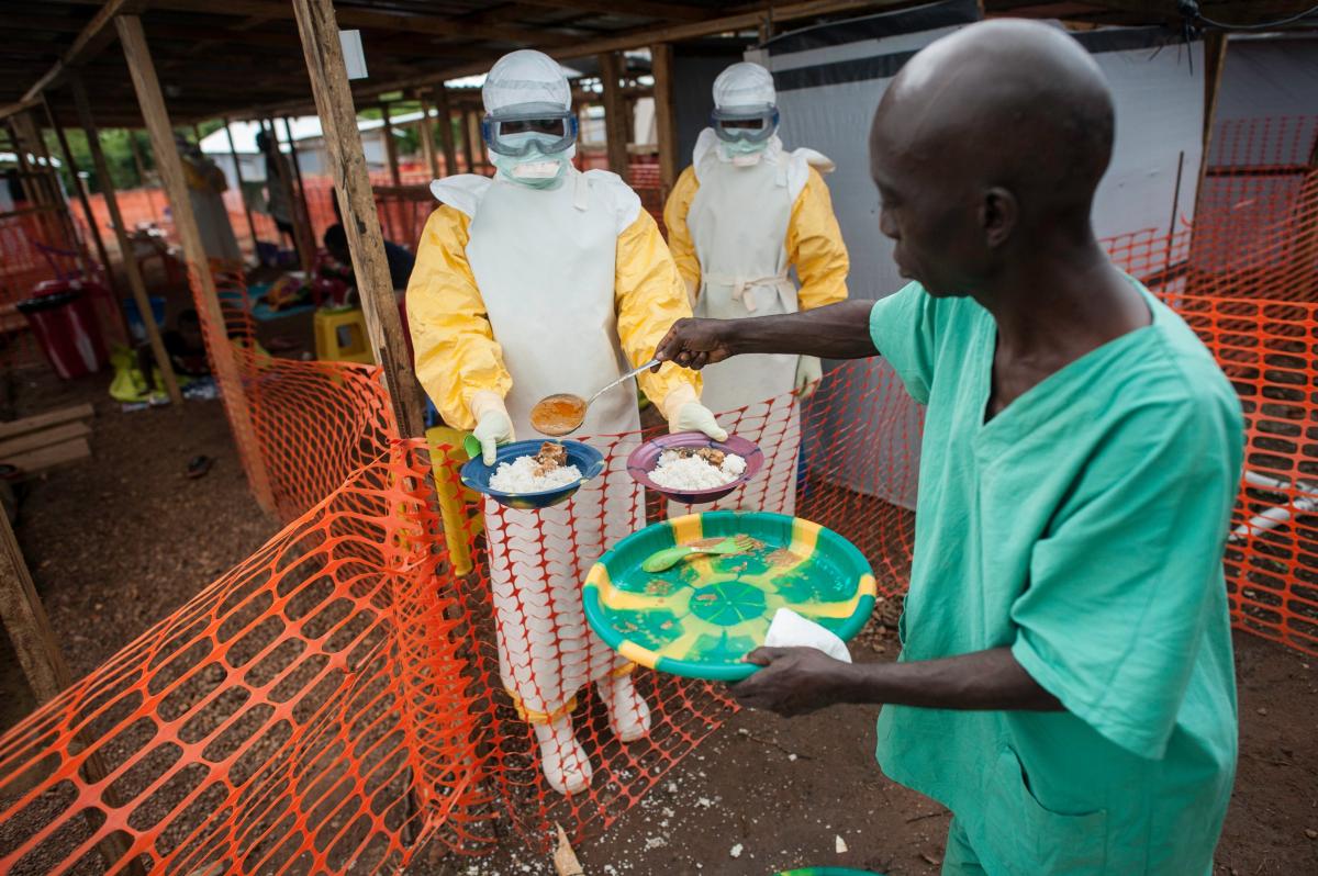塞拉利昂的伊波拉治療中心內，身處低風險區的工作人員派發飯餸到高風險區的工作人員，再派給病人。© Sylvain Cherkaoui/Cosmos