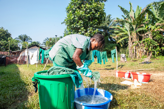 Disinfecting clothes after contact with Ebola. Photo: Louise Annaud/MSF