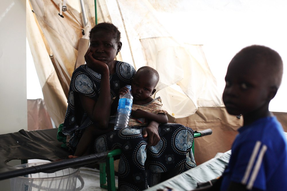 29岁的凯吉（Mary Keji）与她两个孩子—4岁的马修（Matthew）和2岁半的卢迪亚（Ludia）。这两个孩子同样接受了霍乱治疗。© Andreea Campeanu