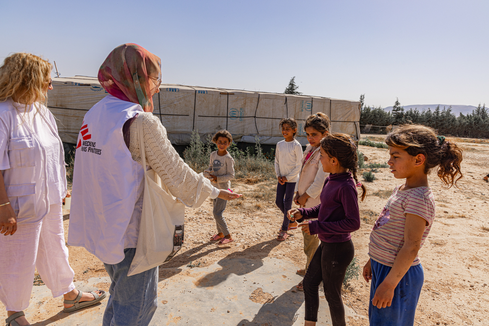 MSF teams are accompanied by children as they roam an informal tent settlement in Qaa, northeast Lebanon. © Carmen Yahchouchi for MSF